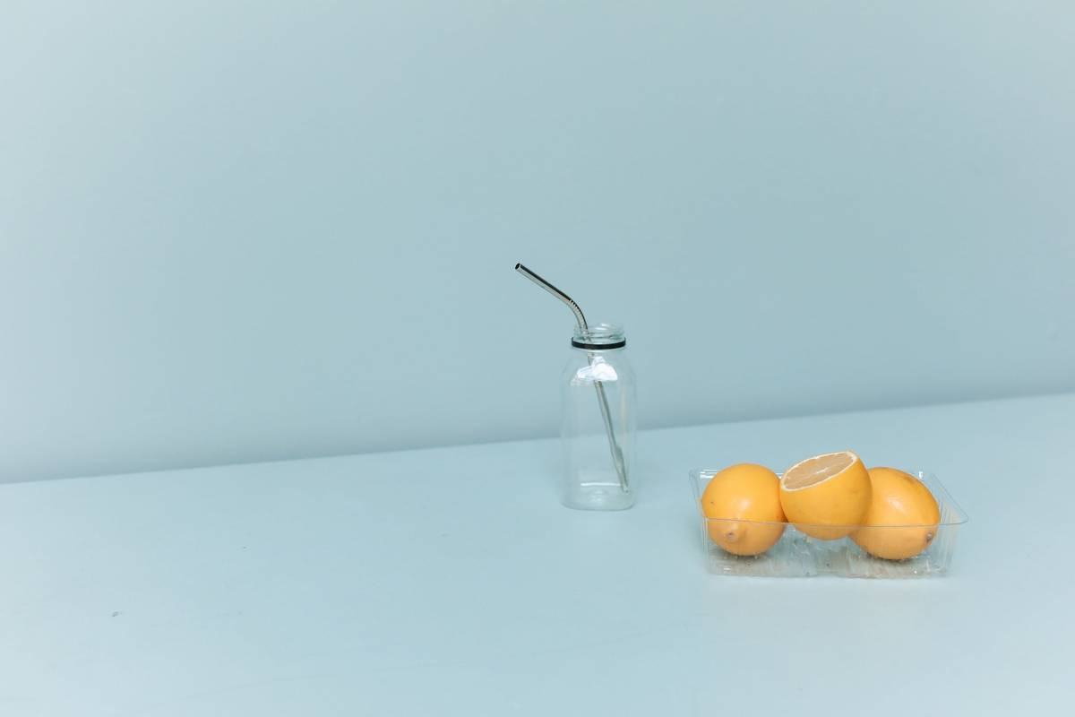 how to clean a lemon zester – close-up of stainless steel zester being scrubbed with a toothbrush under running water